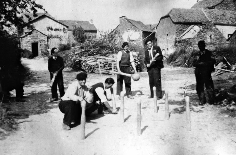 Joueurs de quilles (quilhaires) devant tas de bois de chauffage (lenha) et fagots (fagòts, fornilha), à Puech Amans