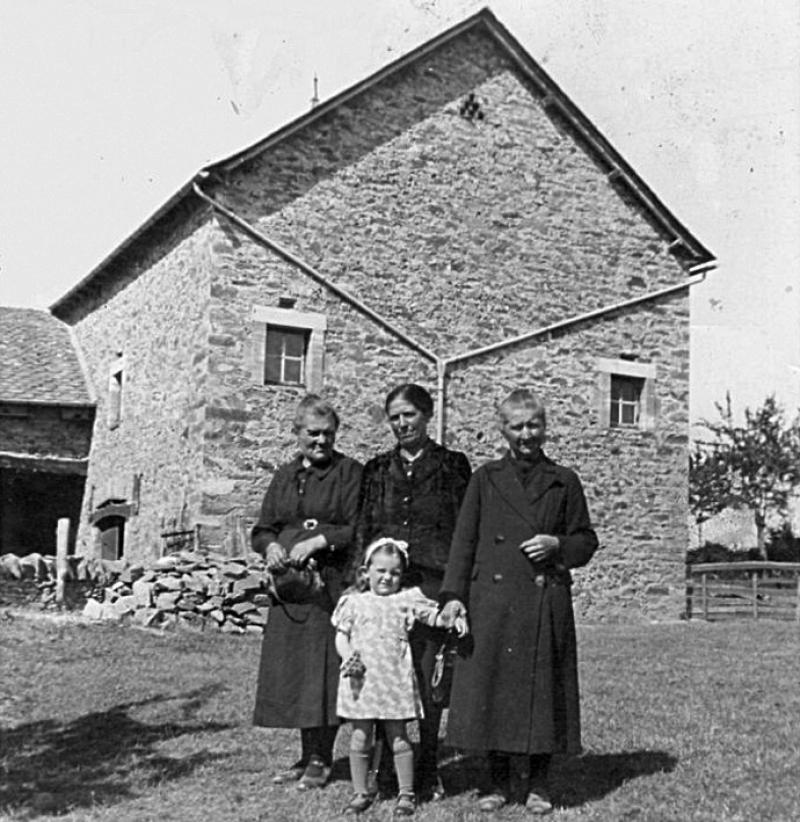 Trois femmes et une jeune fille devant un mur pignon (capial) de grange (granja, fenial), 1944