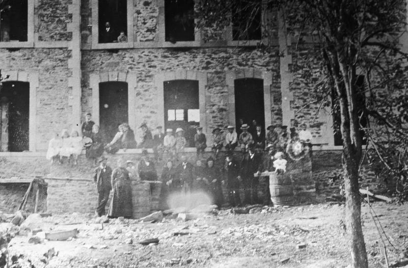 Famille et enfants devant une maison de maître (ostal de pagés) en construction, à Frons, 1902