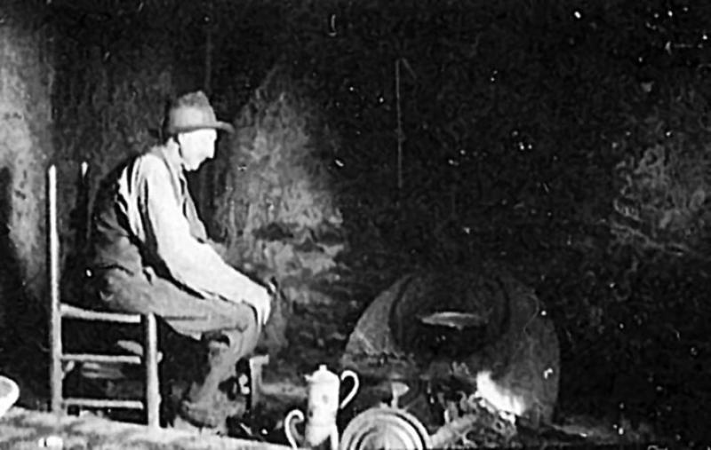 Homme se chauffant au coin du feu (canton), dans le Naucellois (secteur de Naucelle)