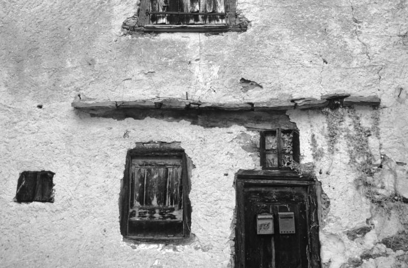 Linteau (lindal, lundar) en bois, fenêtres (fenèstras) et porte (pòrta) protégés par des pierres plates dépassantes, dans le Naucellois (secteur de Naucelle), 1992