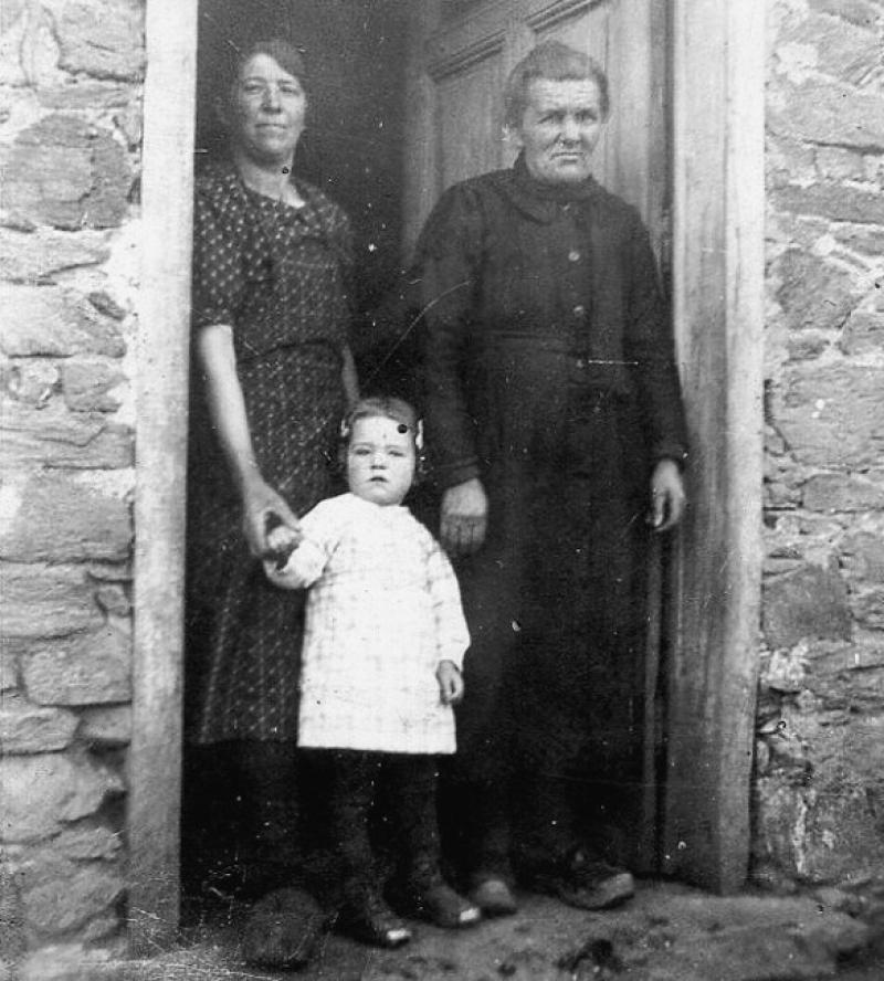 Deux femmes avec une fillette (drolleta) sur le pas de porte d'une maison (ostal), à Grascazes, 1942