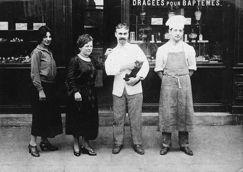 Employé (emplegat) et patrons du Ségala (secteur de Baraqueville-Sauveterre : Sauveterre de Rouergue ?) devant une confiserie, à Paris (75), 1923