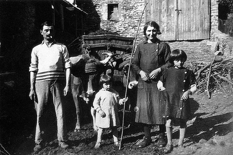 Couple avec deux enfants devant paire de bovidés (parelh) et tombereau (tombarèl) chargé de fumier (fems), aux Garrigues, 1939