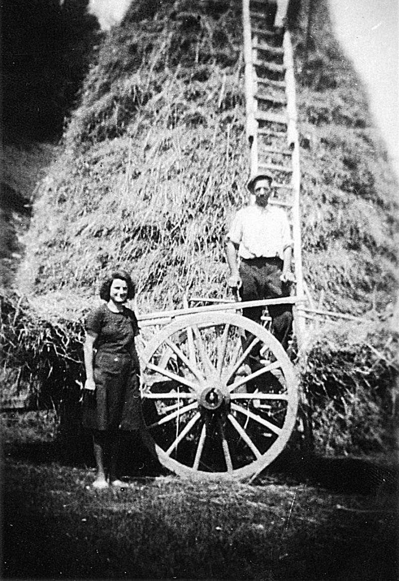 Femme devant et homme sur un char (carri) devant un gerbier (plonjon) en cours de confection, en Ségala (secteur de Baraqueville-Sauveterre : Moyrazès ?), 1947