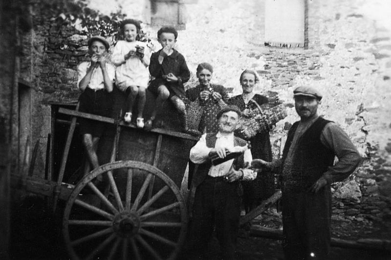 Enfants et femmes mangeant du raisin (rasim) sur un char (carri) et homme versant à boire, au Peyrou, 1938