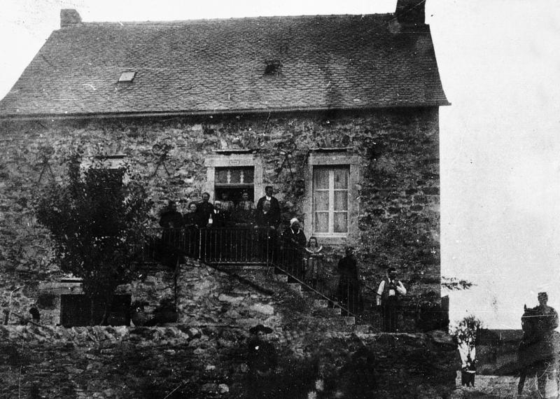 Famille sur le balcon ou dans les escaliers (escalièrs) d'une maison (ostal), homme juché sur un équidé, à Jouels, 1904
