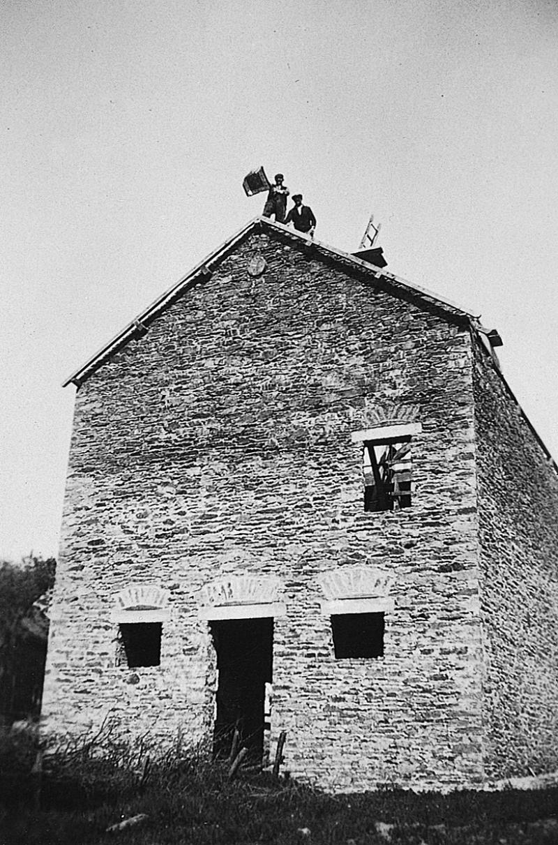 Homme dépliant un foulard sur la charpente d'une grange (granja, fenial) en construction, à L'Issanchou, 1940