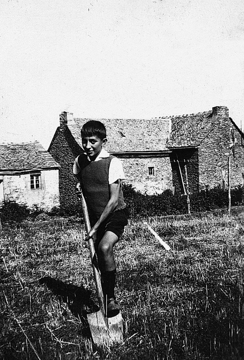 Temps de pause d'un garçon pelle-bêchant (palabaissar) devant des maisons (ostals), 1935