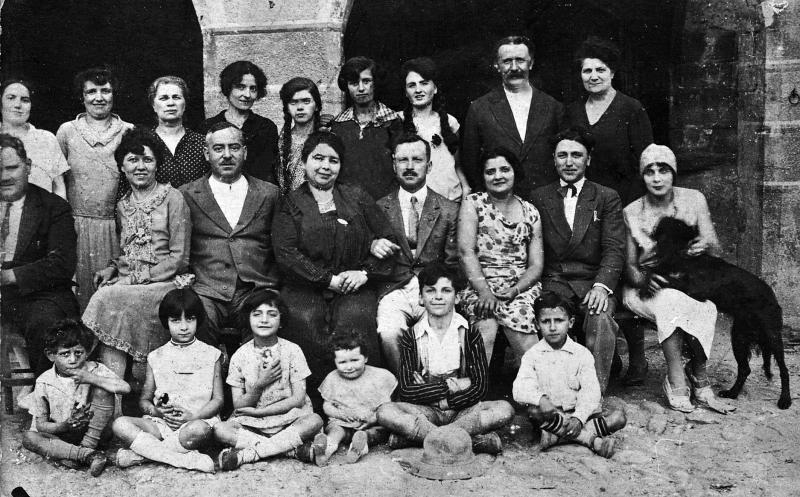 Famille devant le bureau de l'enregistrement et l'épicerie (espiçariá) de Mme Gras, 1927-1928