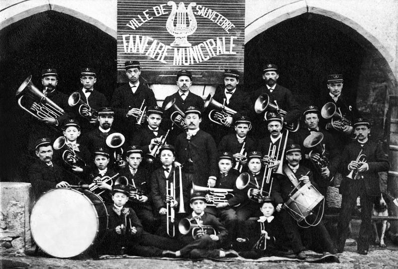 Fanfare (fanfara) municipale en uniforme devant des arcades (gitats), vers 1880