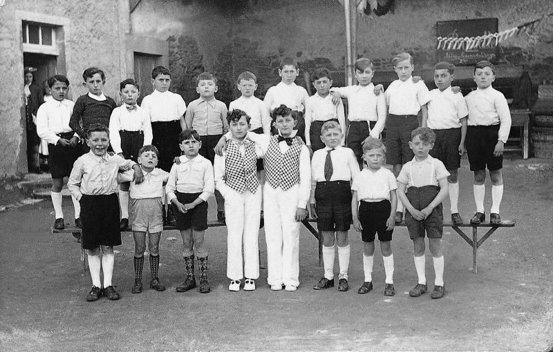 Ecoliers (escolans) de l'école (escòla) publique, dont deux costumés, pour la pièce de théâtre “La ronde des petits coiffeurs”, Rameaux 1936
