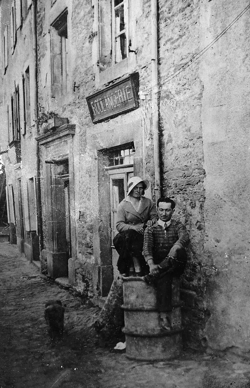 Couple (coble) juché sur un bidon en fer devant une boulangerie (bolanjariá) en face les couverts (gitats), 1932