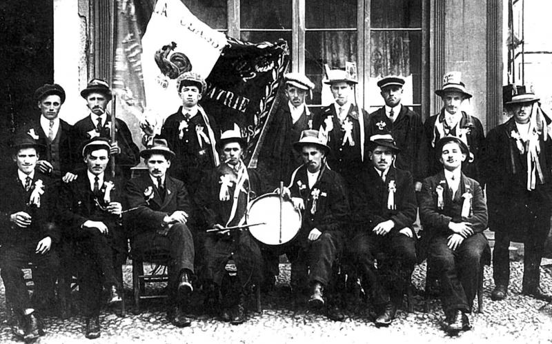 Conscrits avec joueur de tambour (tambor) devant une devanture (veirina), classe 1922